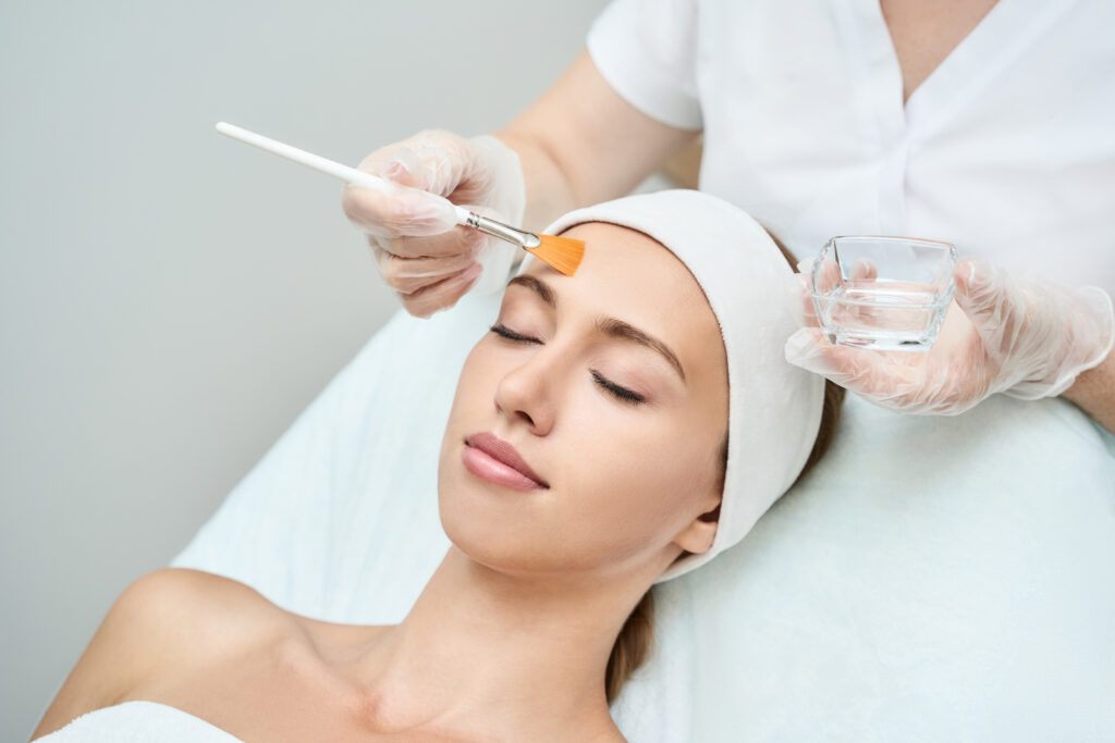 Esthetician applying chemical peel on woman face | Fayced Aesthetics NYC | New York, NY